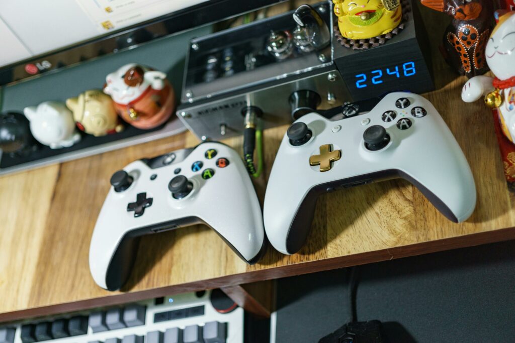 Deux manettes de jeu vidéo sur un bureau, évoquant les loisirs numériques et le divertissement à domicile.